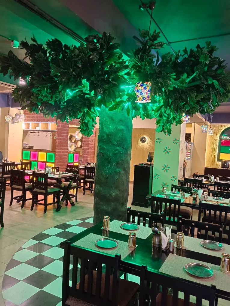 Owner-uploaded photo of the leafy indoor tree and colourful dining area at Pind Balluchi Sarjapur Road