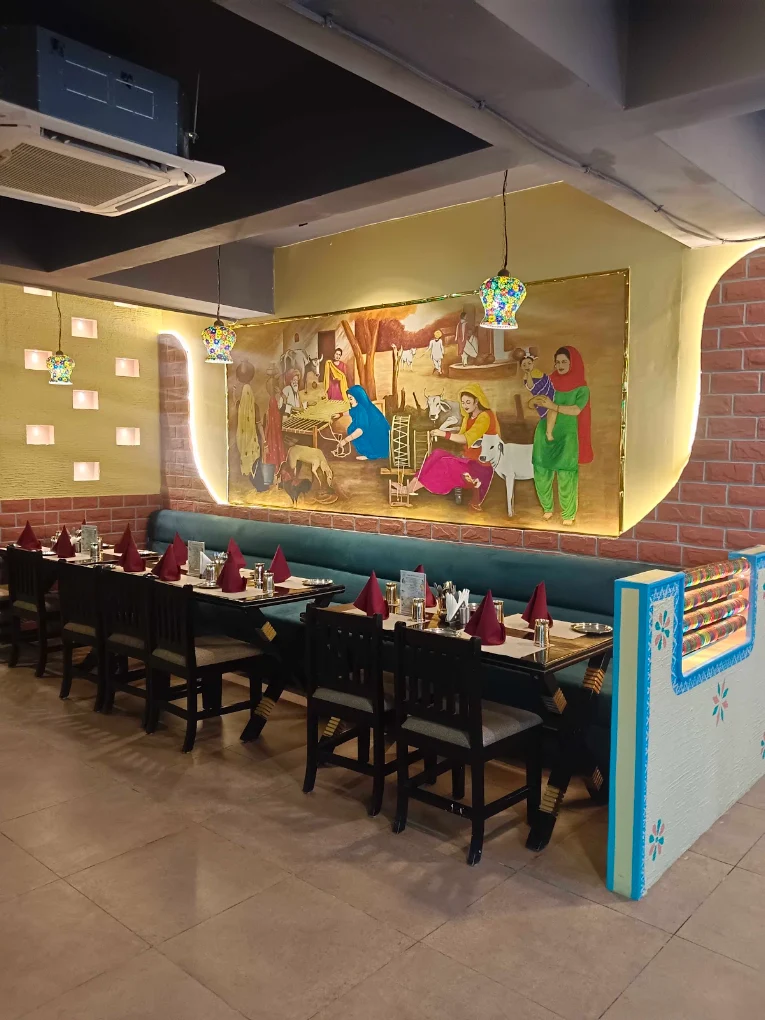 Owner-uploaded photo of traditional Punjabi village wall artwork and dining tables at Pind Balluchi Sarjapur Road